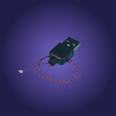 Green electronic component with red and white wires on a blue background