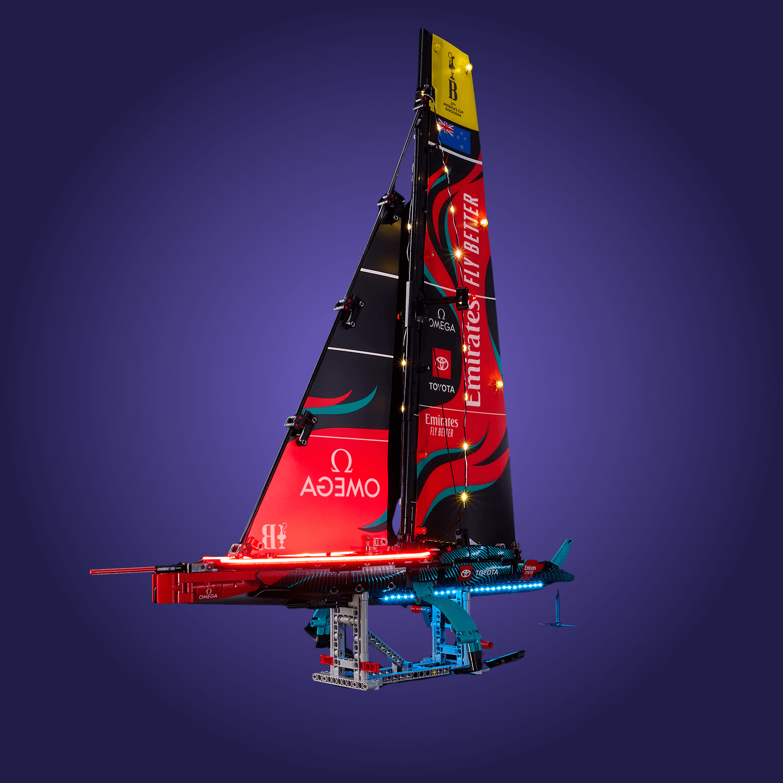 Model of a sailboat with red and black design on a dark blue background